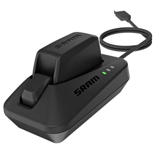 En svart SRAM batteriladdare med ett insatt batteri, som visar tre gröna indikatorlampor, och en ansluten USB-kabel för laddning.