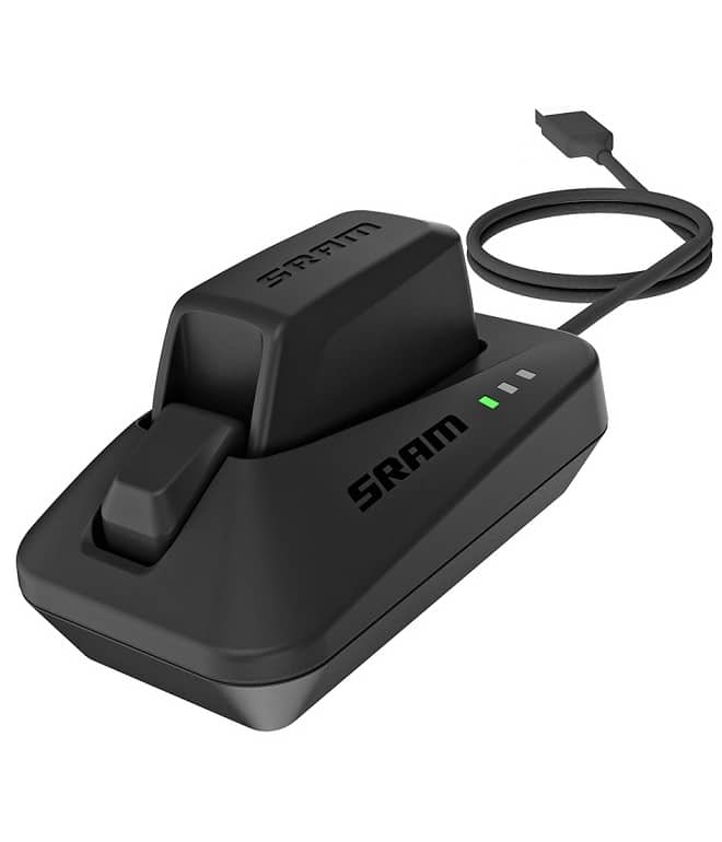 00_3018_117_000_27718.jpg En svart SRAM batteriladdare med ett insatt batteri, som visar tre gröna indikatorlampor, och en ansluten USB-kabel för laddning.