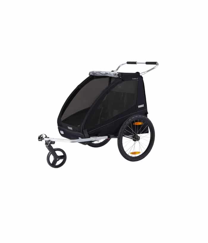 10101810.jpg En svart tvåhjulig cykelkärra med nätöverdrag, sidofönster, framhjulsfäste och ett styre för att skjuta eller dra. Släpvagnen har reflexer på hjulen och är avsedd för transport av barn eller last.