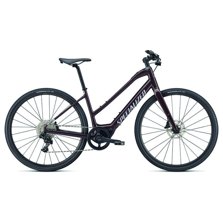 90422-72_COMO-30-REDTNT-SILREFL_HERO-1.jpg En mörkfärgad cykel med genomgående ram, platt styre, smala däck, skivbromsar och ordet "Specialized" tryckt på ramen, visad i sidoprofil mot en vit bakgrund.