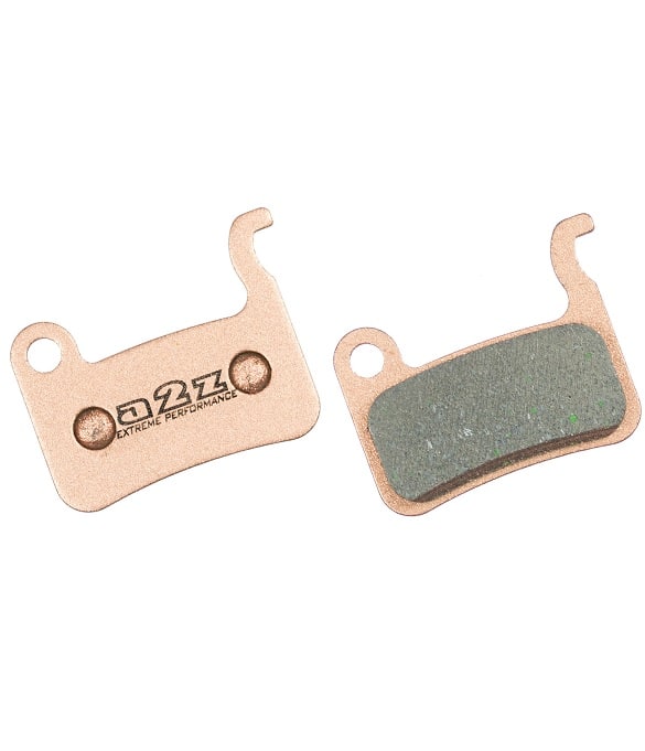 A2Z-630S.jpg Två bromsbelägg av metall, det ena med en platt metallplatta med texten "Q2X Extreme Performance" och det andra med en yta av friktionsmaterial fäst på en liknande platta.
