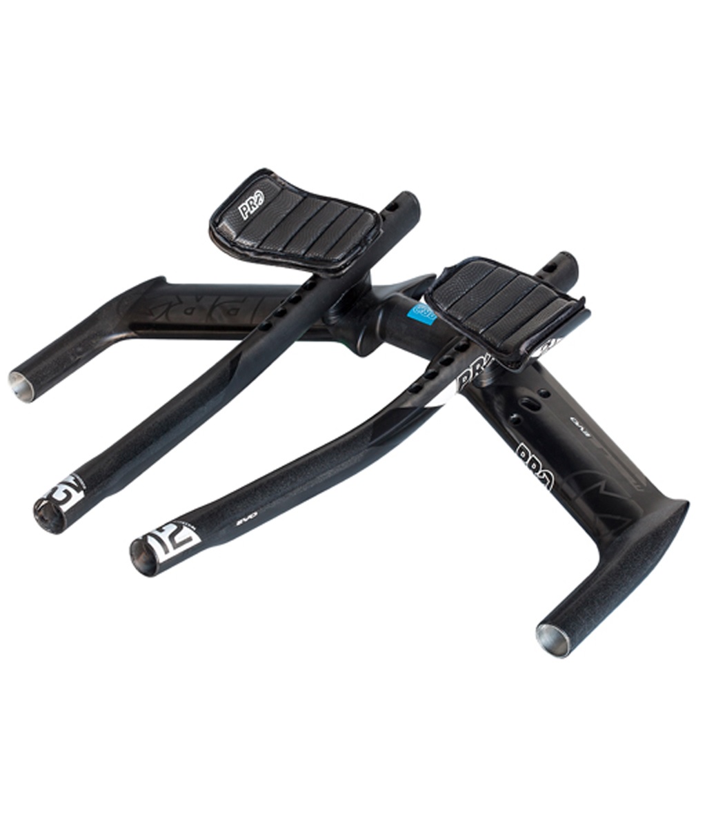 Aerobar-Missile-EVO-Carbon.jpg En uppsättning svarta aerodynamiska cykelstyren med integrerade armstöd och grepp, utformade för cyklar för tidskörning eller triathlon, mot en vit bakgrund.