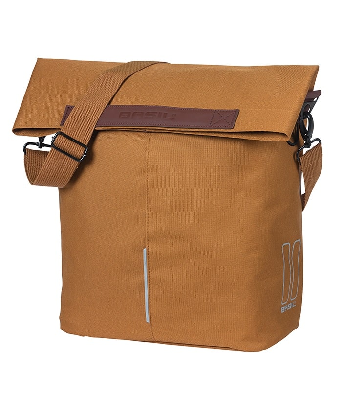 Basil-City-Shopper-brun1.jpg En axelremsväska i brun canvas med uppfällbar toppklaff, justerbar rem och en liten reflexremsa nära botten. Varumärket "Basil" syns på en läderlapp och är tryckt i det nedre högra hörnet.