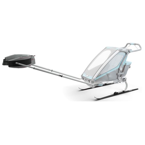 En modern, sluten släde med genomskinligt tak, metallram och skidor, fäst vid en lång dragstång med en täckt sektion i slutet, avsedd för transport på snö.
