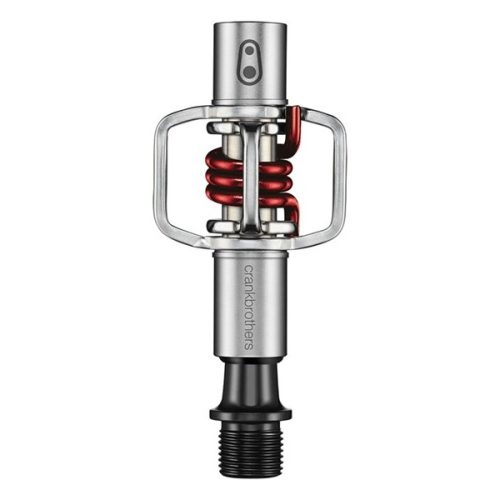 En silverfärgad och svart cykelpedal med en röd fjäderspiral och en öppen, minimalistisk design. Ordet "crankbrothers" är tryckt vertikalt på pedalens metallskaft.