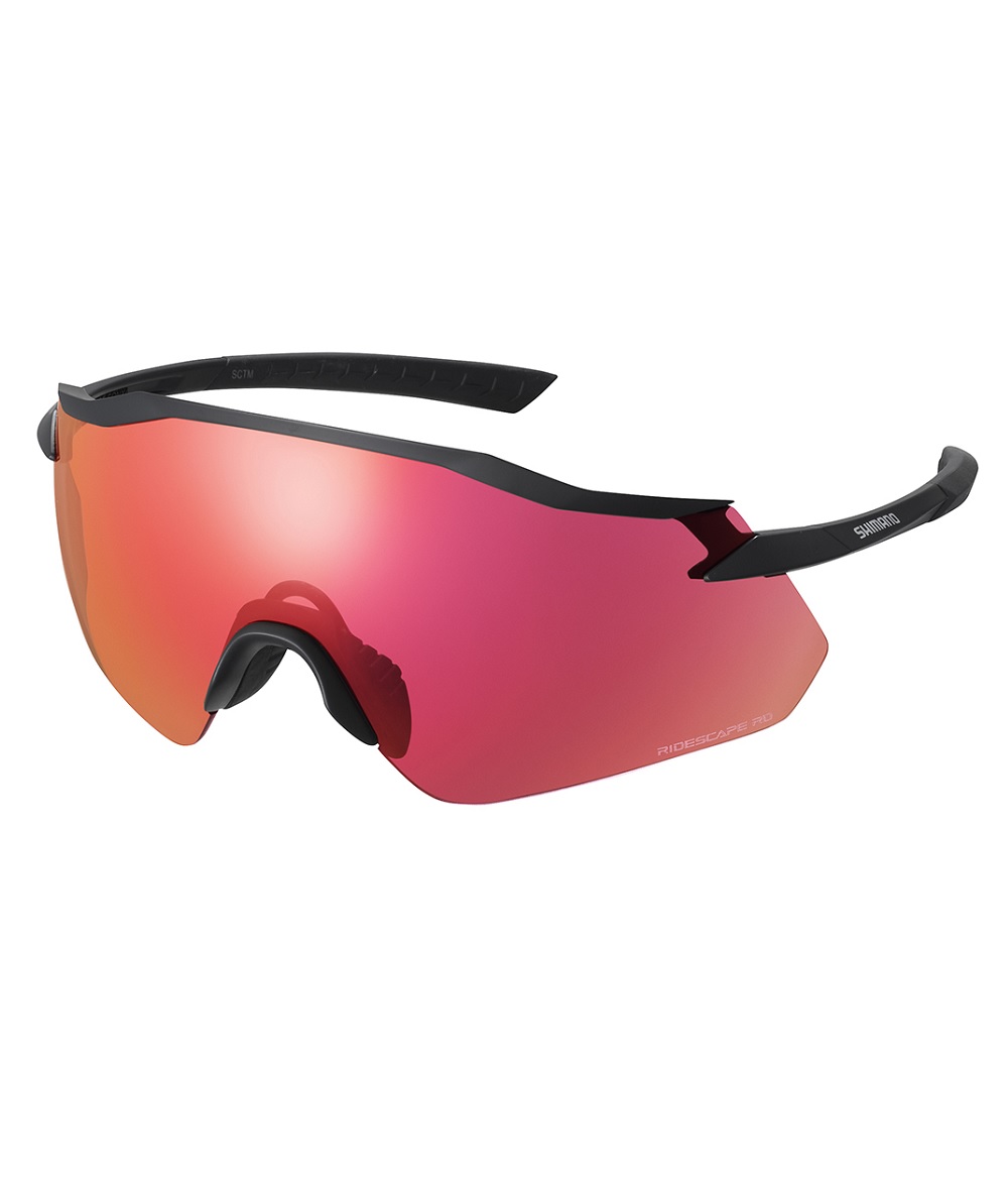 Equinox-4-RD-svart.jpg Ett par sportsolglasögon med ett enda stort, böjt rödtonat glas och en tunn svart båge. Bågen har en rak övre båge och böjda armar med varumärket synligt på sidan.