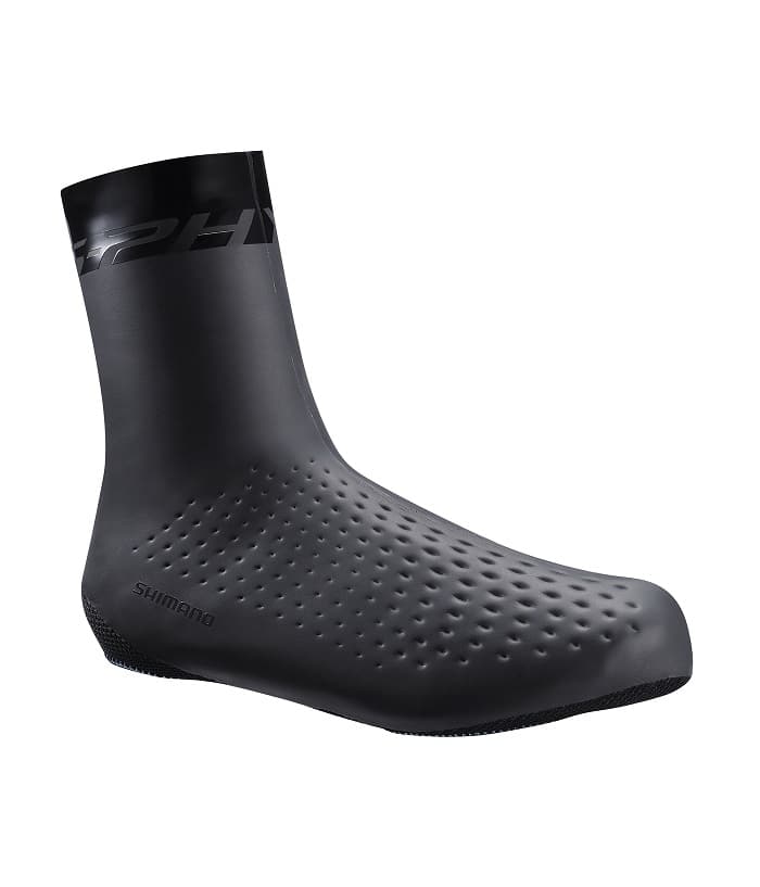 Insulated-Shoe-Cover.jpg Ett svart, strömlinjeformat cykelskoöverdrag med en texturerad, prickig yta och en hög ankelskärning. Shimano-logotypen är synlig nära hälen.