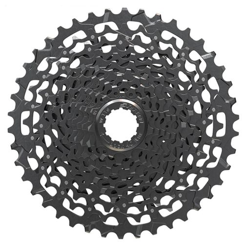 En närbild av en svart cykelkassett med flera växlar i ett cirkulärt mönster, sedd uppifrån mot en vit bakgrund.