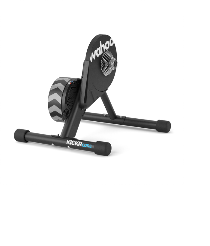 Kickr-core.png En stationär cykelmaskin för inomhusbruk märkt "Wahoo KICKR CORE" med svart ram, chevronmönster på svänghjulet och kassett för att fästa en cykel.