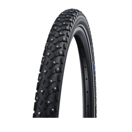 Närbild av ett svart cykeldäck med framträdande slitbana och små metalldubbar för bättre grepp, mot en vit bakgrund.