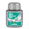 En silverfärgad och grå flaska märkt "Bike Grease 2000" från Motorex rymmer 100 gram produkt. Etiketten har blå och gröna färger, text på flera språk och en liten bild av fett som appliceras.