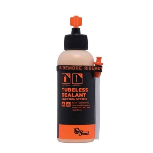 En flaska RideMore Tubeless Sealant med ett anslutet injektionssystem och orange lock. Etiketten anger att den tätar tubeless- och icke-tubeless-däck och är lämplig för mountainbikes, gruscyklar och landsvägscyklar.