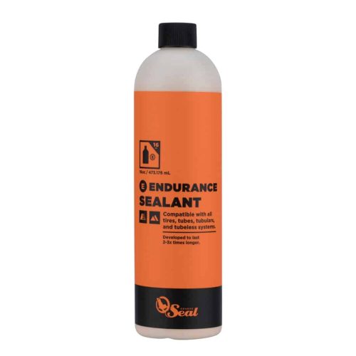 En flaska Orange Seal Endurance Sealant med en orange etikett. Texten anger att den är kompatibel med alla däck, slangar, tubeless och tubeless-system och är utvecklad för att hålla 2-3 gånger längre.