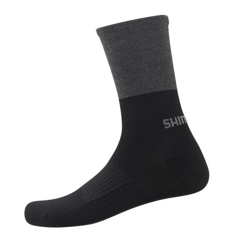 En enkel strumpa med svart fot och underben och mörkgrå överdel. Strumpan har ordet "SHIM" synligt i ljus text nära vristen.