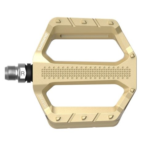 En guldfärgad Shimano cykelpedal med en platt plattform, texturerad greppyta och en axel märkt "R" för höger. Pedalen har en bred, öppen design med avfasade kanter och synligt varumärke.