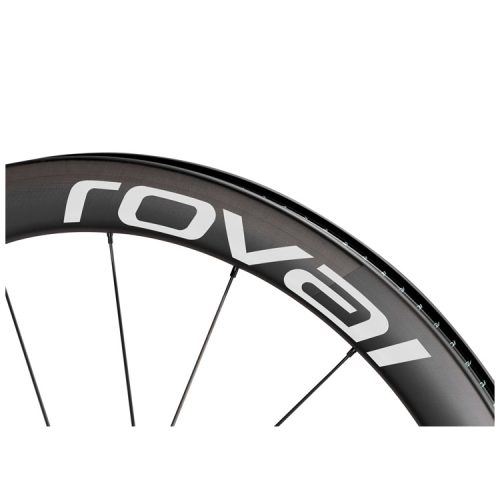 Närbild av en svart cykelfälg med vitt "roval"-märke, som visar en del av fälgen och flera ekrar mot en vit bakgrund.