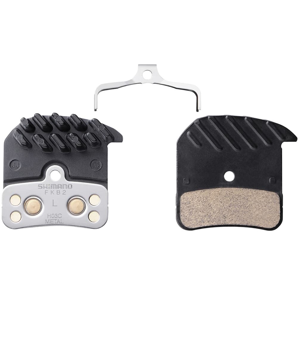 Saint-Zee-H03C-Metall.jpg Två svarta Shimano skivbromsbelägg med en silverfärgad metallfjäderklämma, visade framifrån och bakifrån. Beläggen har en metallkonstruktion och kylflänsar för värmeavledning.