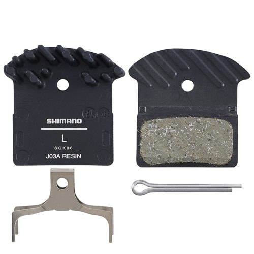 En uppsättning Shimano J03A skivbromsbelägg av harts, inklusive två bromsbelägg med kylflänsar, en metallfjäder och en silverfärgad fäststift, allt arrangerat på en vit bakgrund.