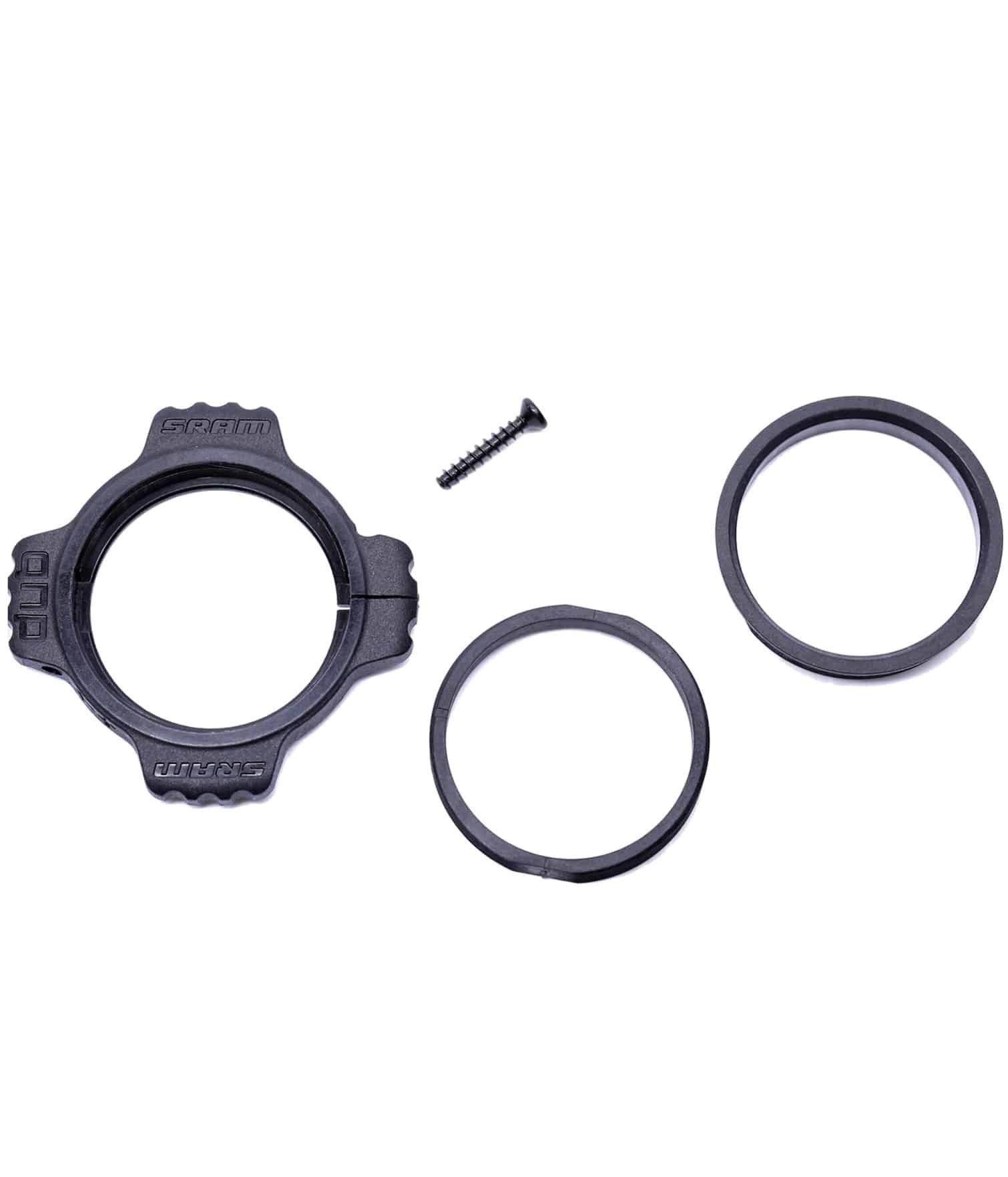 Sram-BBkit-Preload-adjuster-Dub.jpg En uppsättning cykelkomponenter i svart plast och metall, inklusive ett cirkulärt fäste med flikar, två ringar och en enda skruv, arrangerade mot en vit bakgrund.