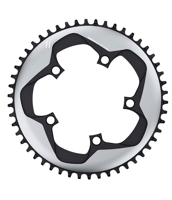 Sram-Xsync-11-Argon.jpg Närbild av en cykelkedja med fyra monteringshål och jämnt fördelade tänder runt kanten, mot en vit bakgrund.