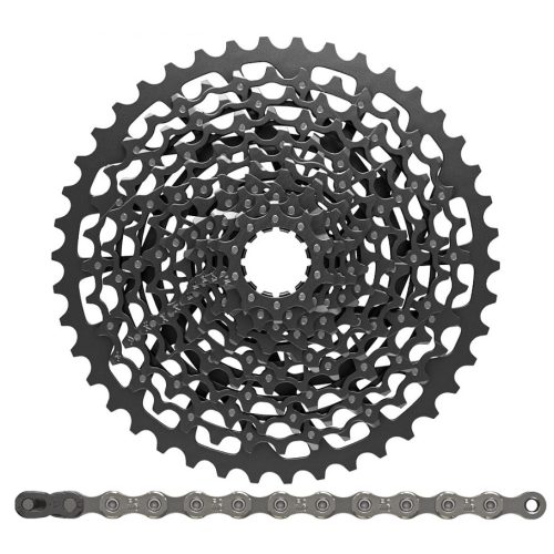 Närbild av en cykelkassett med flera växlar staplade i ett cirkulärt mönster, ovanför en rak cykelkedja som ligger horisontellt mot en vit bakgrund.