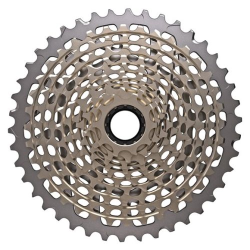 En närbild av en metallisk cykelkassett med flera koncentriska kedjehjul och ett centralt monteringshål, fotograferad uppifrån mot en vit bakgrund.
