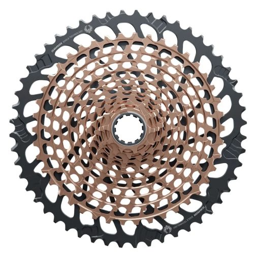 Närbild på en cykelkassett med flera kugghjul i koncentriska cirklar, med en blandning av svarta och bronsfärgade metallkugghjul.