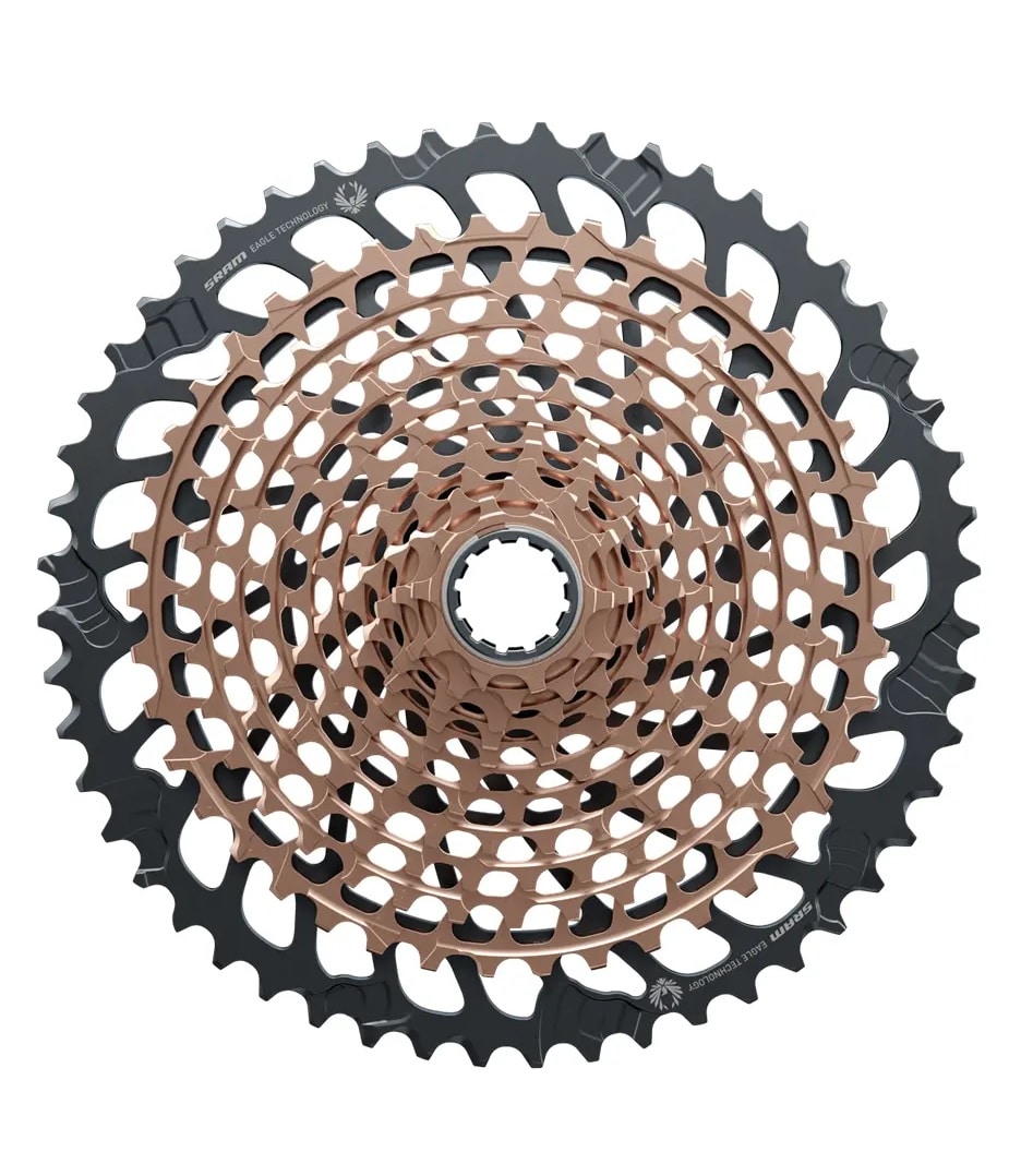 XG-1299-Eagle.jpg Närbild på en cykelkassett med flera kugghjul i koncentriska cirklar, med en blandning av svarta och bronsfärgade metallkugghjul.