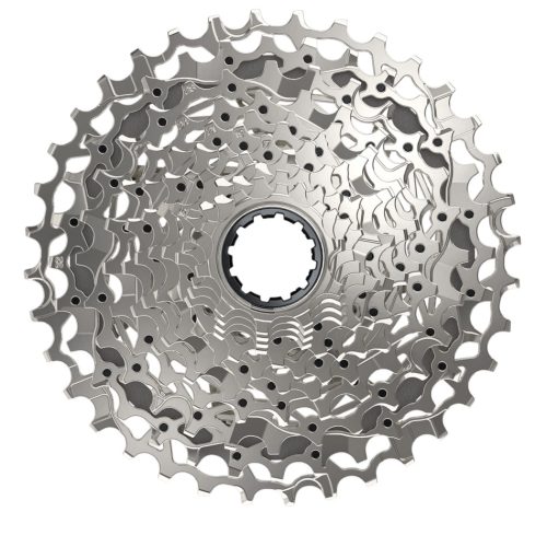 En närbild av en silvrig cykelkassett med flera kedjehjul, arrangerade i ett cirkulärt mönster, isolerad mot en vit bakgrund.