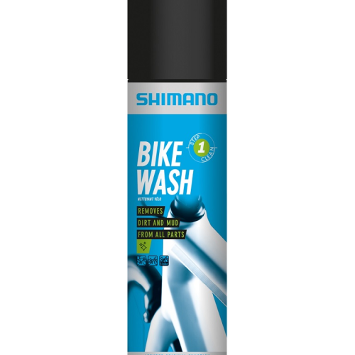 En burk Shimano Bike Wash med en blå och svart etikett med text som anger att den tar bort smuts och lera från alla delar och säkerställer originalfunktionen. Burken har vit och blå cykelgrafik.