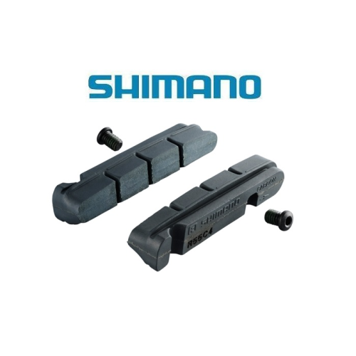 Två svarta Shimano-bromsbelägg för cyklar visas med två små skruvar mot en vit bakgrund. Den blå Shimano-logotypen visas ovanför bromsbeläggen.