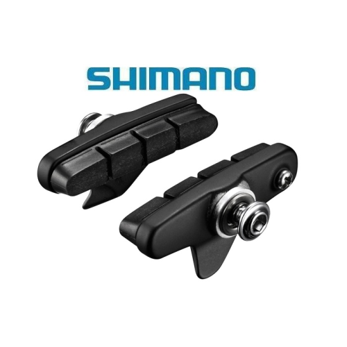 Två svarta Shimano-cykelbromsbelägg med metallhårdvara visas mot en vit bakgrund