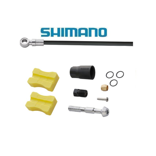 Hydraulisk skivbromsslangsats av märket Shimano med smådelar inklusive två gula block, en svart koppling, en metallinsats, en mässingsoliv, tre O-ringar och en bult, arrangerade mot en vit bakgrund.