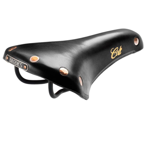 En Brooks Colt cykelsadel i svart läder med kopparnitar och "Colt" skrivet i guld på sidan, monterad på en svart metallram.