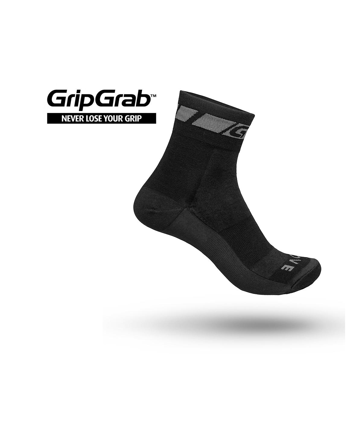 gripgrab-wool-sock-merinoull.png En enda svart GripGrab-strumpa med ett subtilt grått mönster hänger mot en vit bakgrund. GripGrab-logotypen och sloganen "Never Lose Your Grip" visas i det övre vänstra hörnet.