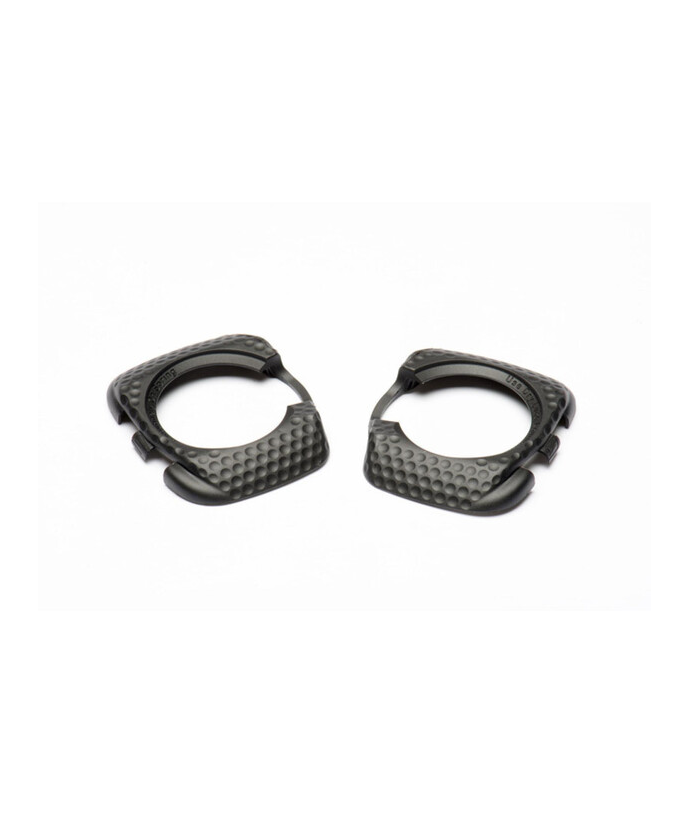 pedalskydd-speedplay-svart.png Två svarta, runda föremål av texturerad plast eller metall med öppna sektioner, placerade sida vid sida mot en vit bakgrund. De har en gropig yta och ser ut att vara matchande delar eller tillbehör.
