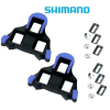 Ett par Shimano SPD-SL blå landsvägscykelklossar med hårdvara, inklusive bultar och metallplattor, på en vit bakgrund med Shimanos logotyp högst upp.