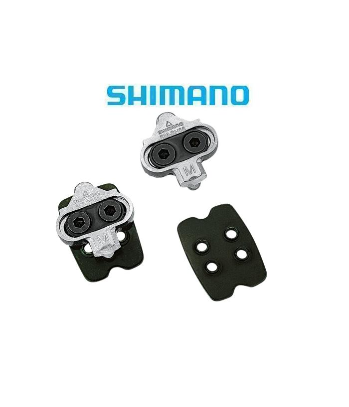 shimano-spd-smsh56.png Ett par Shimano SPD-cykelklossar och två svarta rektangulära plattor visas på en vit bakgrund med den blå Shimano-logotypen ovanför dem.