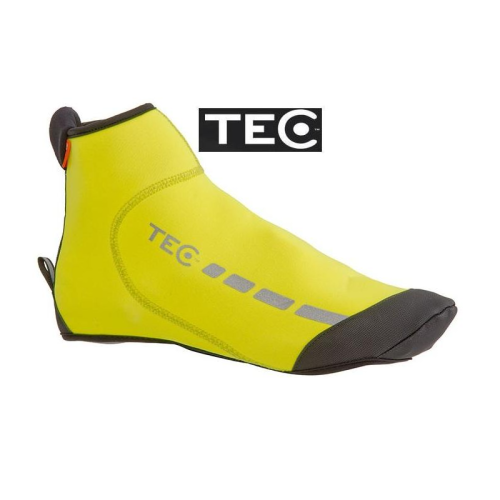Ett gult cykelskoöverdrag med TEC-märke med svarta förstärkningar på tå och häl, reflekterande detaljer och en liten dragflik vid hälen. TEC-logotypen visas ovanför skoöverdraget.
