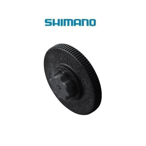 En svart Shimano-cykeldel, möjligen en växel eller ett kedjehjul, visas mot en vit bakgrund med Shimano-logotypen ovanför.