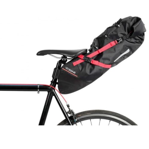 En svart cykel med en stor svart sadelväska fäst under sadeln, säkrad med röda remmar. Cykeln har ett synligt bakhjul och en del av ramen.