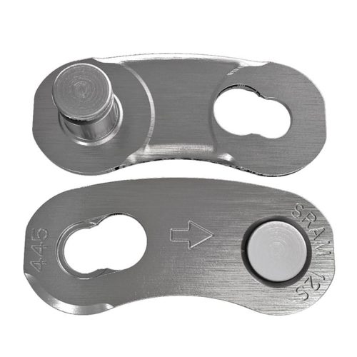 Närbild på ett silverfärgat Sram PowerLock Eagle Flattop 12-växlat kedjelås. Detaljerade ytor fångas i starkt ljus, vilket framhäver metallens borstade textur och ingraverade markeringar.