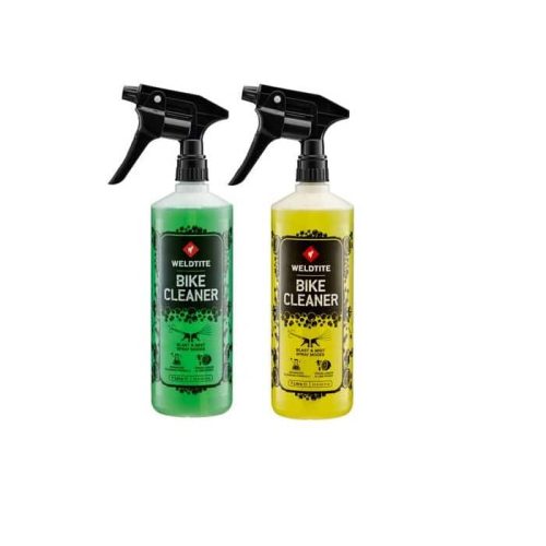 Två flaskor Weldtite Bike Cleaner, en grön och en gul, står bredvid varandra mot en vit bakgrund. Flaskorna har spraymunstycken och etiketterna är tydliga. Belysningen är jämn och detaljrik.