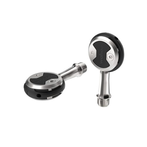 Två Racerpedal Wahoo Speedplay Zero Stainless pedaler visas mot en vit bakgrund. Den ena ligger ner och den andra står upp. Metalliska ytor och stark belysning betonar produktdetaljerna.
