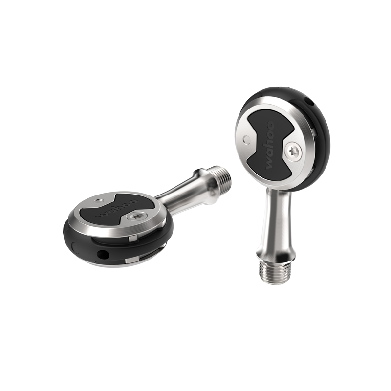 150251_SpeedplayZero_1 Två Racerpedal Wahoo Speedplay Zero Stainless pedaler visas mot en vit bakgrund. Den ena ligger ner och den andra står upp. Metalliska ytor och stark belysning betonar produktdetaljerna.
