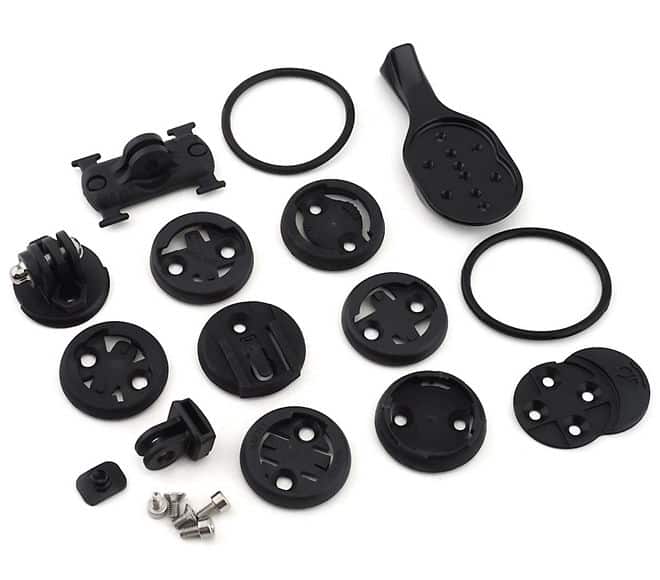 20021-190_CMPNT_STEM-ACCESSORY-MOUNT_HERO.jpg Närbild av Specialized Stem Accessory Mount-kit, som visar olika fästen, adaptrar, gummiringar och skruvar i svart, arrangerade på en ljus bakgrund, vilket framhäver detaljerna i tillbehören.