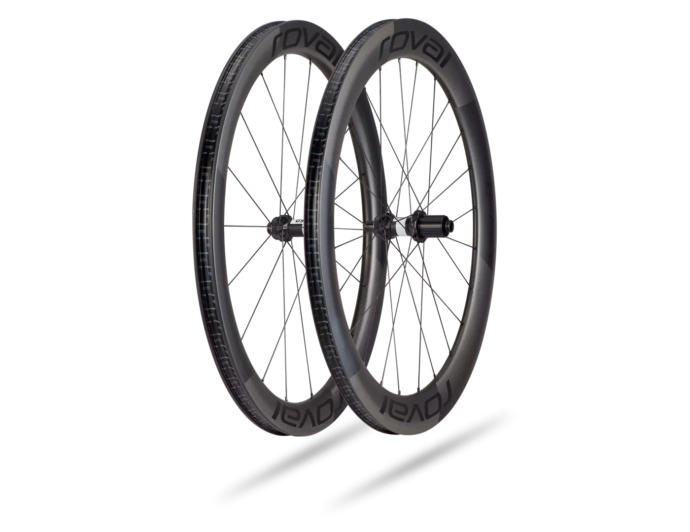 30021-510_WHL_RAPIDE-CL-HG-CARBON-BLK-700C_HERO (1) Två Roval Rapide CL II Disc hjulpar för racer, fram och bak, presenteras mot en vit bakgrund. Detaljerade ekrar och Roval-logotypen syns tydligt i mjukt, diffust ljus.