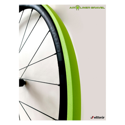 Närbild av ett cykelhjul med ett limegrönt Vittoria Airliner Gravel däckinlägg. Hjulet har svarta ekrar och en mörk fälg. God belysning framhäver detaljerna i däckets textur och hjulkonstruktionen.