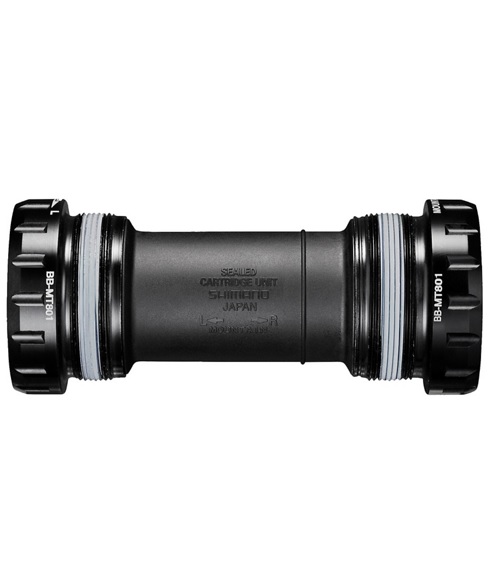 BB-MT801-Shimano Ett detaljerat fotografi av ett Shimano XT BB-MT800 vevlager, BSA 68/73 mm. Vackert ljus framhäver vevlagerets svarta färg, med betoning på Shimano-logotypen och produktmärkningen.