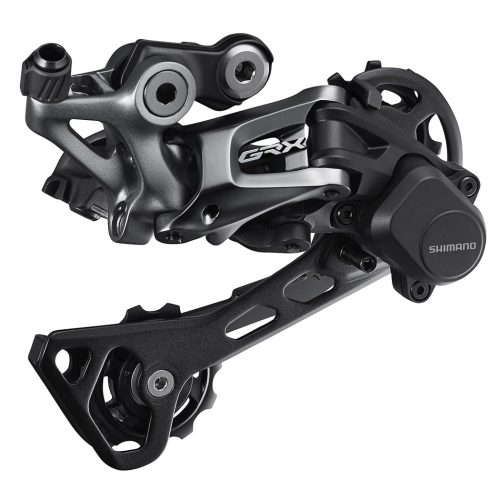 En detaljerad närbild av en Shimano GRX RD-RX812 1x11s bakväxel. Belysningen framhäver de metalliska och svarta komponenterna, vilket ger ett tekniskt och högkvalitativt intryck.